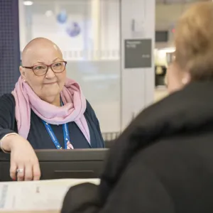 Dame i resepsjon som smiler