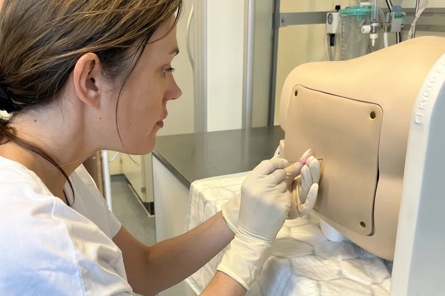 Lege som gjør en undersøkelse på en dukke