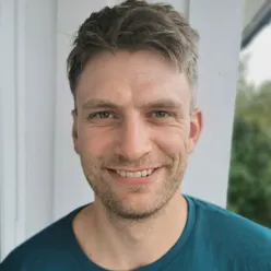 En mann som smiler til kameraet