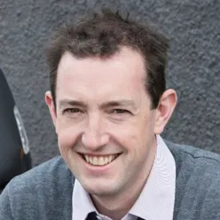 En mann som smiler til kameraet