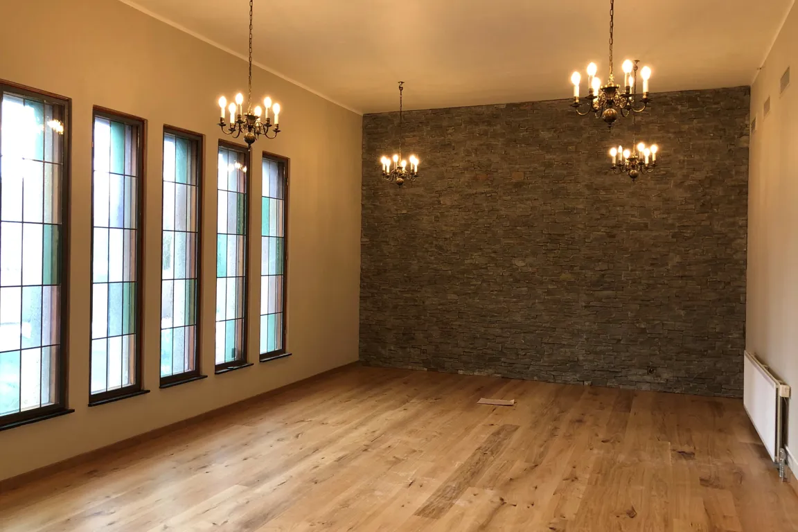 A room with a wood floor and a wall with lights