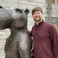 En mann som står ved siden av en statue