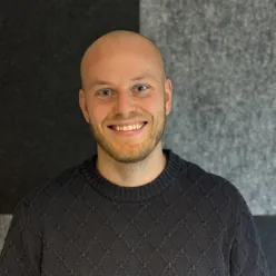En mann som smiler til kameraet