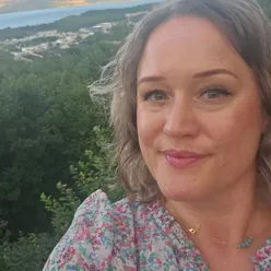 En kvinne som smiler til kamera