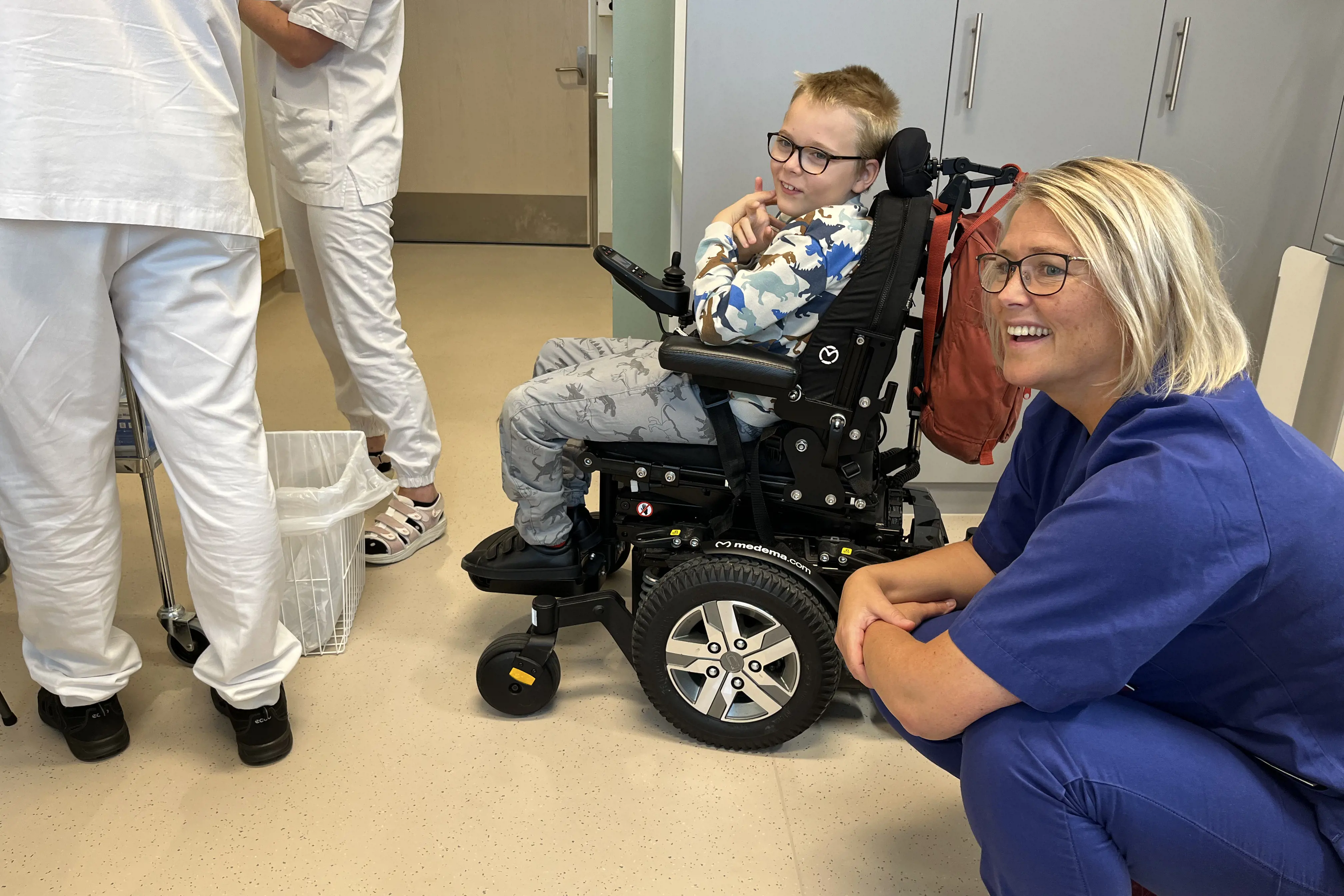 sykepleier og gutt i rullestol sammen