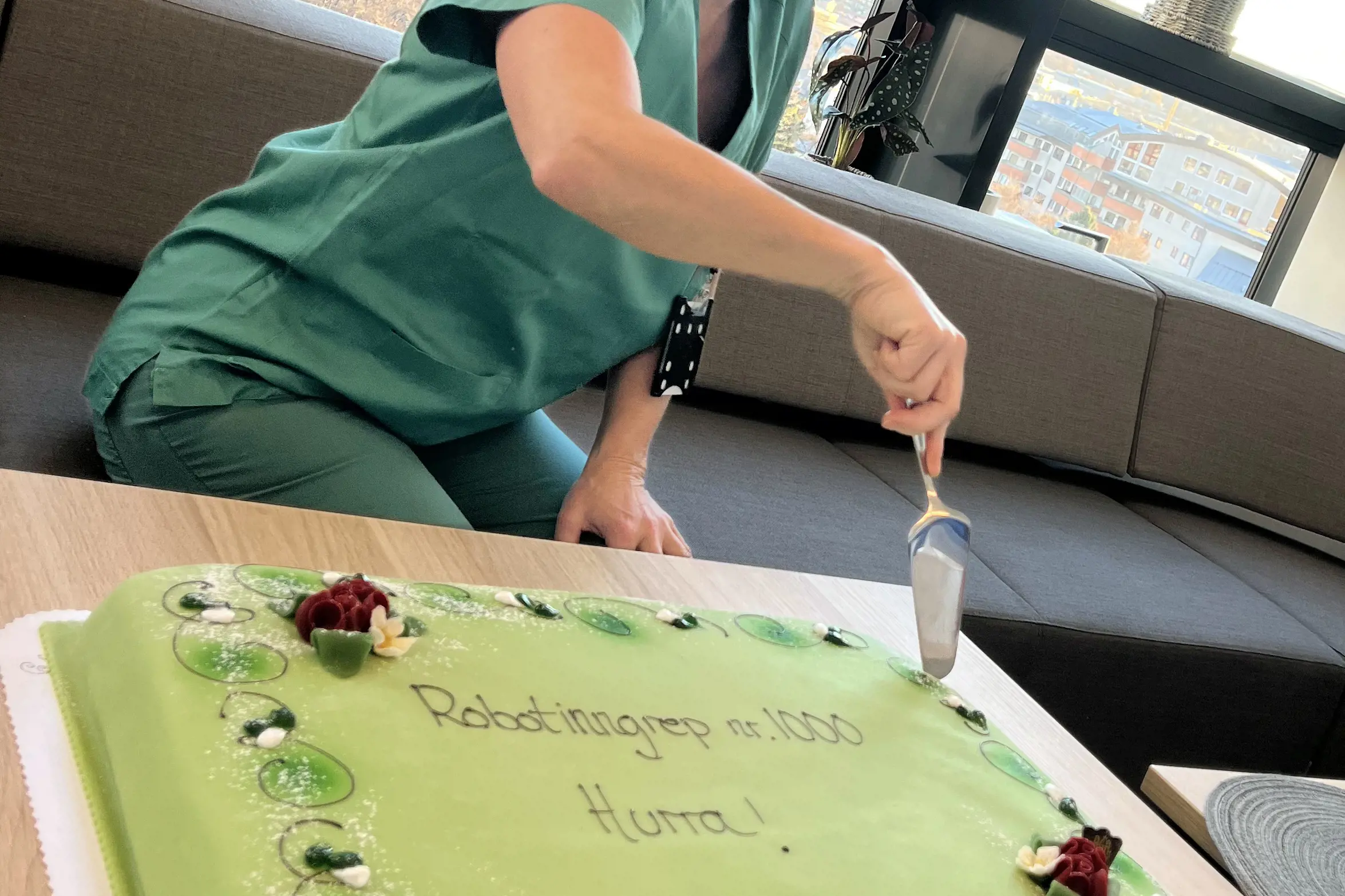 Operasjonssykepleier skjærer opp grønn kake