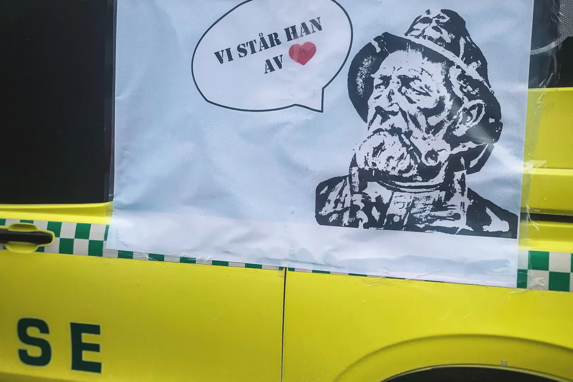 Ambulanse med plakat med teksten "Vi står han av"