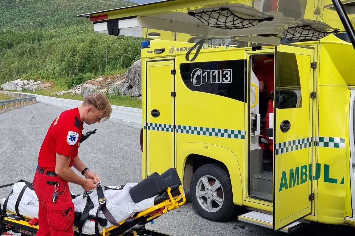 Mann med båre utenfor ambulanse