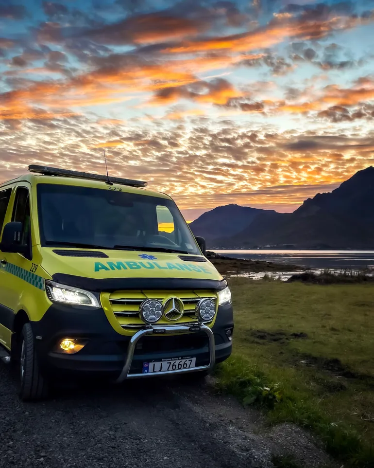 Ambulanse med fin natur bak seg