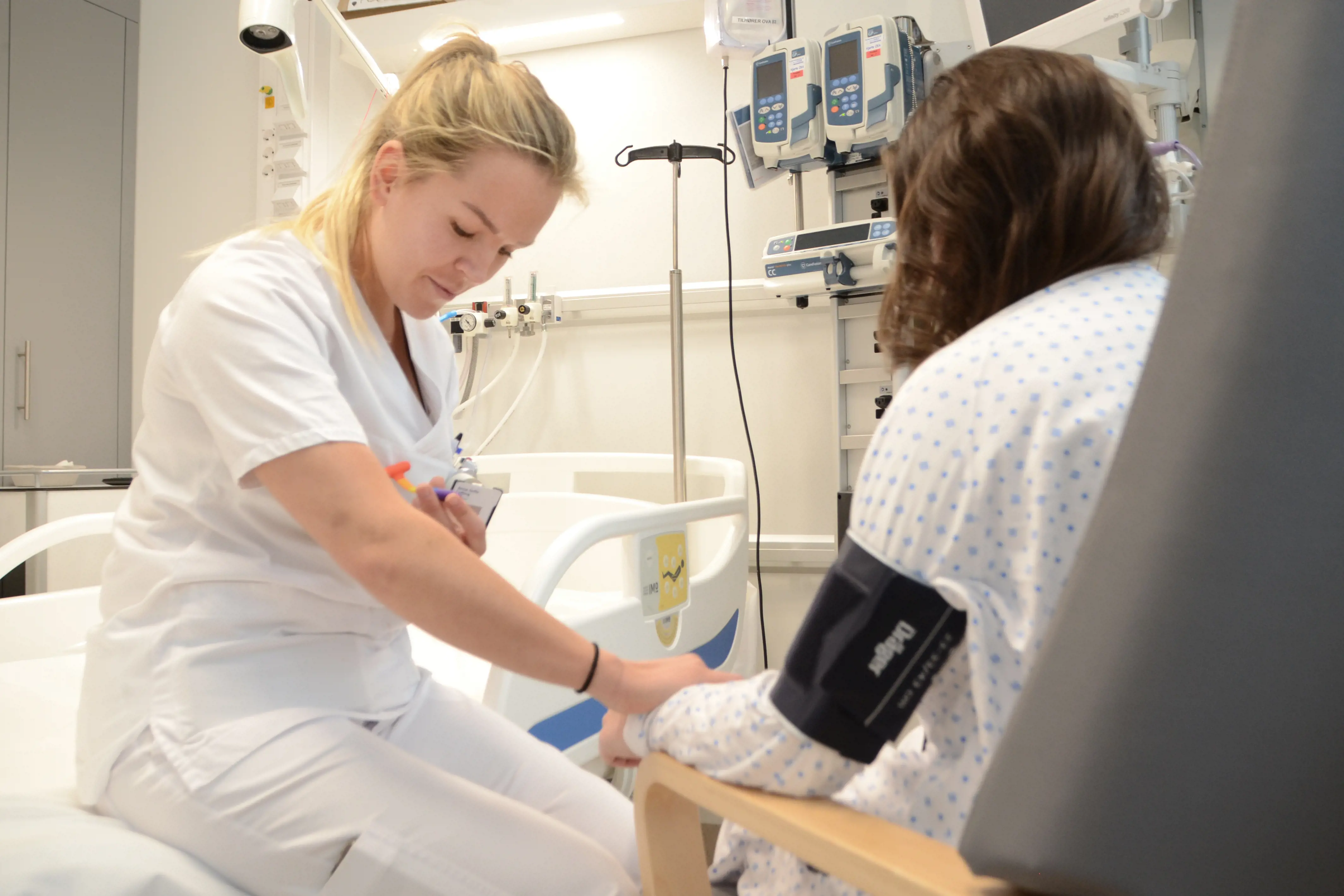 Sykepleier måler blodtrykk på pasient