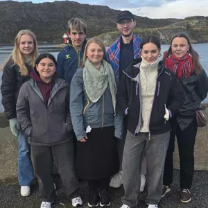 En gruppe mennesker som poserer for et bilde utendørs