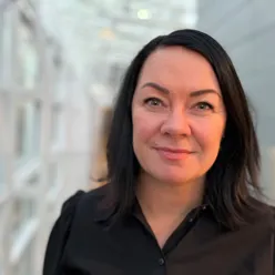 En kvinne som smiler til kameraet