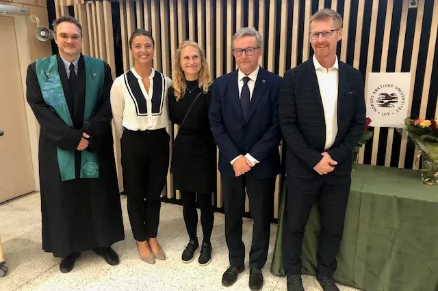 Fem personer oppstilt og smilende mot kamera