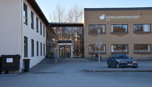 En bil parkert foran en bygning