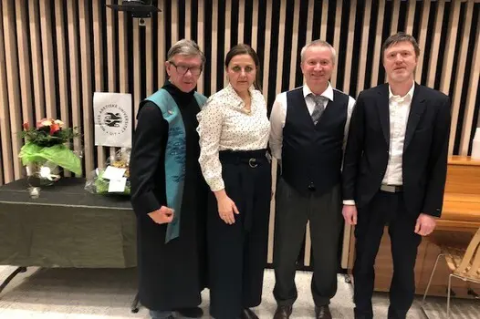 Fire personer som står samlet mot kamera